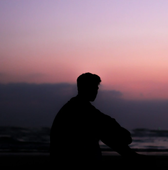 silhoutte of man sitting on ground